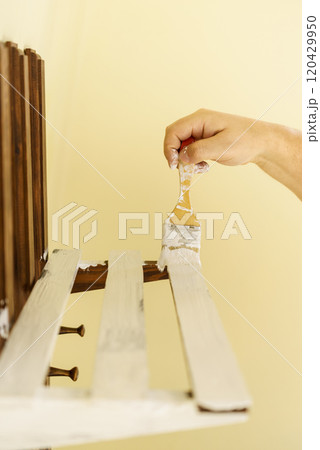 Person renovating wooden hanger 120429950