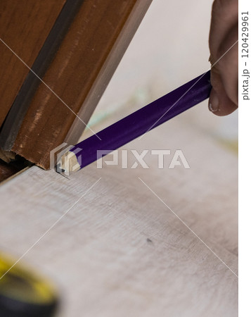 Man measuring floor panels 120429961