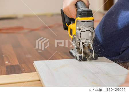 Person cutting floor panels 120429963
