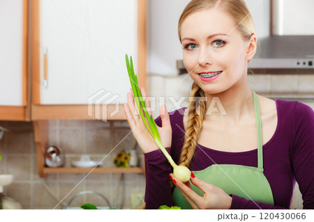 Woman in kitchen holds green fresh chive Woman in kitchen holds green fresh chive 120430066