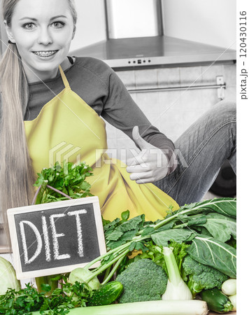 Woman in kitchen having green diet vegetables Woman in kitchen having green diet vegetables 120430116