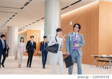 オフィスのホールで話しながら歩くビジネスパーソン オフィスのホールで話しながら歩くビジネスパーソン 120430159