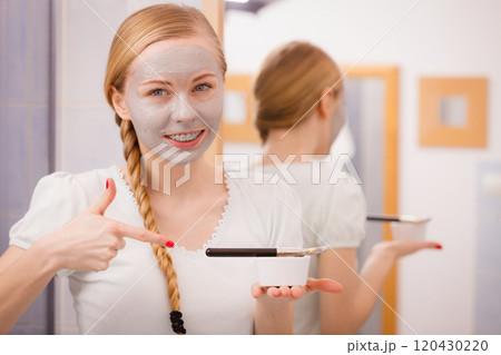 Woman applying with brush clay mud mask to her face Woman applying with brush clay mud mask to her face 120430220