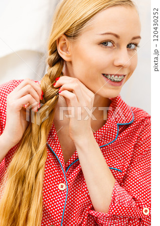 Woman doing braid on blonde hair 120430252
