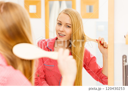 Woman brushing her long hair in bathroom Woman brushing her long hair in bathroom 120430253