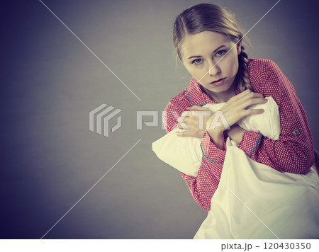 Sad depressed girl in bed gripping pillow Sad depressed girl in bed gripping pillow 120430350
