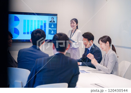 会議室でプレゼンをする若い女性 120430544