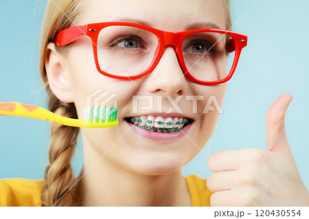 Woman with teeth braces using brush 120430554