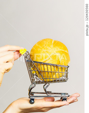 Hand holding shopping cart with bread Hand holding shopping cart with bread 120430560