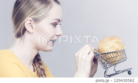 Woman holding shopping cart with bread Woman holding shopping cart with bread 120430562