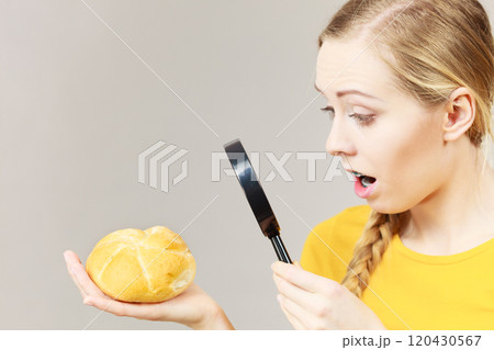 Shocked woman magnifying bun bread roll Shocked woman magnifying bun bread roll 120430567