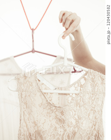 Woman in shop or wardrobe picking dress 120430582