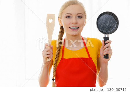 Woman holding cooking pan and spatula Woman holding cooking pan and spatula 120430713