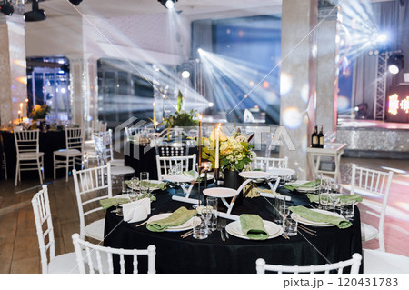 Elegant banquet hall setup with floral centerpieces, candles, and stylish table arrangements Elegant banquet hall setup with floral centerpieces, candles, and stylish table arrangements 120431783