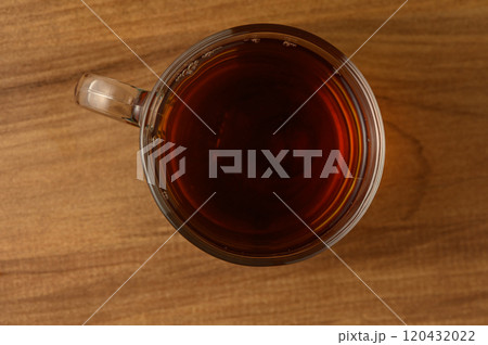 A warm cup of black tea resting on a wooden table, inviting tranquility during a quiet afternoon 120432022