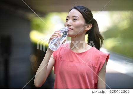 ペットボトルの水を飲むスポーツウエアの若い女性 ペットボトルの水を飲むスポーツウエアの若い女性 120432803