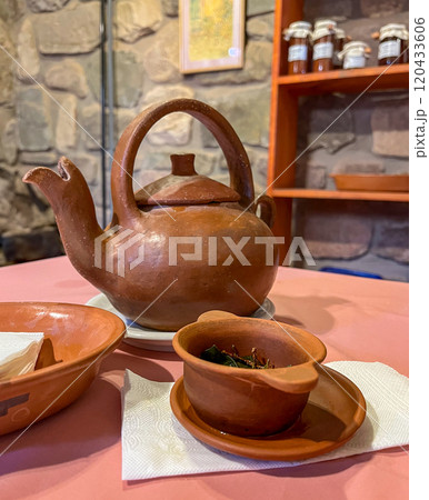 Earthenware teapot and pots with coca tea infusion. Natural medicine. 120433606