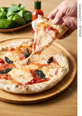 焼きたてのマルゲリータを手に取る 焼きたてのマルゲリータを手に取る 120434043