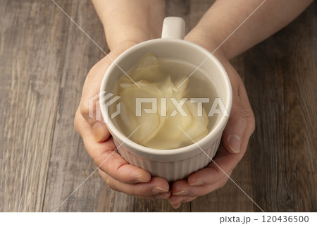 生姜湯の入ったマグカップを手で持つ 120436500