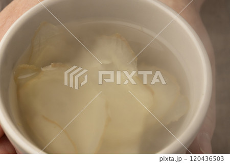 生姜湯の入ったマグカップを手で持つ 120436503