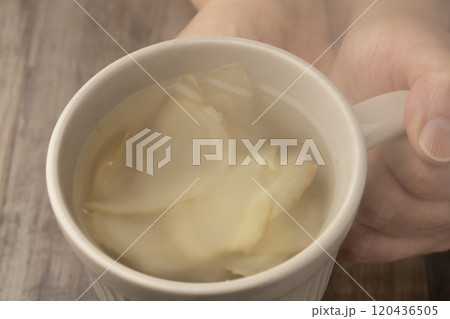 生姜湯の入ったマグカップを手で持つ 生姜湯の入ったマグカップを手で持つ 120436505