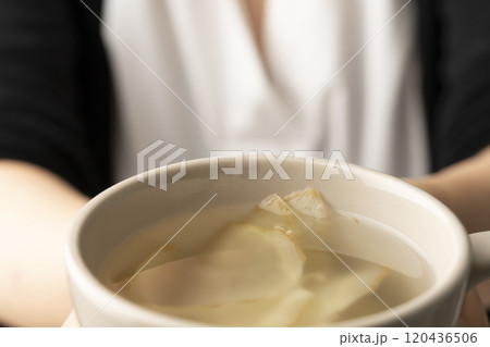 生姜湯の入ったマグカップを手で持つ 120436506