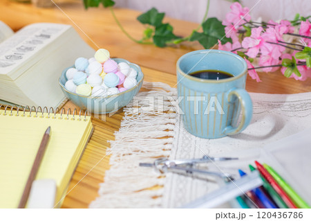 勉強道具と一緒に準備されたコーヒーとラムネ 120436786