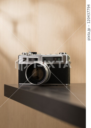 A vintage film camera sits elegantly on a table, showcasing timeless craftsmanship. 120437794