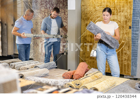 Female buyer chooses soft carpet to create coziness in her apartment Female buyer chooses soft carpet to create coziness in her apartment 120438344