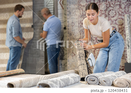 Female buyer chooses soft carpet to create coziness in her apartment 120438431