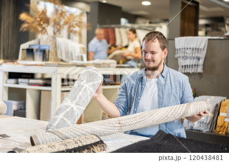 On territory of exhibition hall, guy inspect carpets On territory of exhibition hall, guy inspect carpets 120438481