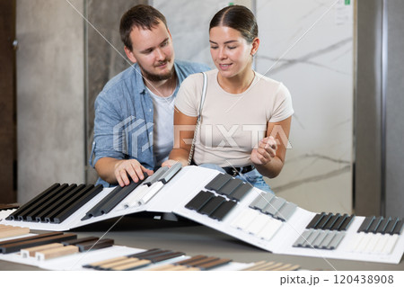 Couple man and woman choosing sample of house siding 120438908