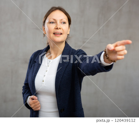 Cheerful woman with wide grin on her face exuding happiness and positivity pointing Cheerful woman with wide grin on her face exuding happiness and positivity pointing 120439112
