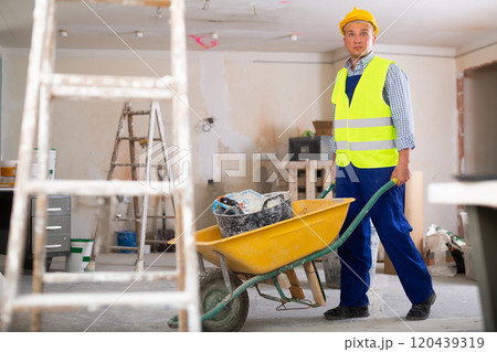 Man builder pushing cart in construction site Man builder pushing cart in construction site 120439319