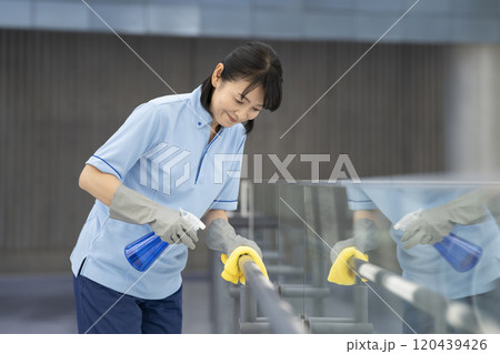 ビル清掃イメージ　通路の手すりを拭く清掃スタッフ 120439426