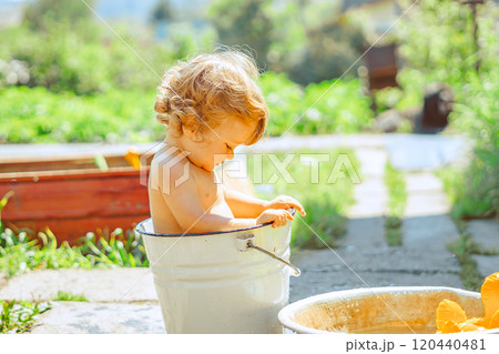 A little boy is bathing in a basin A little boy is bathing in a basin 120440481