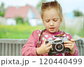A little girl with a camera 120440499