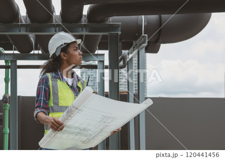Engineers with draft plan of building on constructing site. Engineer working on building site. Engineer working with drawing System plan document 120441456