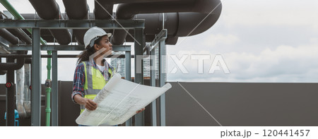 Engineers with draft plan of building on constructing site. Engineer working on building site. Engineer working with drawing System plan document 120441457