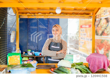 A vendor displays vibrant vegetables at a bustling food stall, showcasing fresh produce A vendor displays vibrant vegetables at a bustling food stall, showcasing fresh produce 120441508