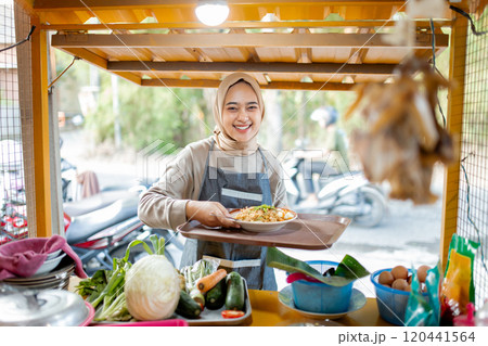 A cheerful vendor serves fresh street food at a vibrant stall, creating joy 120441564