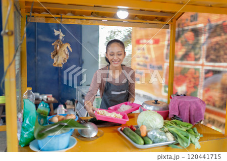 A Joyful Vendor at a Colorful Food Stall Featuring Fresh, Organic Vegetables A Joyful Vendor at a Colorful Food Stall Featuring Fresh, Organic Vegetables 120441715