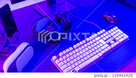 Close up gamer work space gaming set up modern equipment on desk, gaming gear, mouse, headset, computer mouse ready for online streaming 120442420