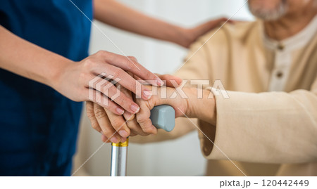 Close up hands of doctor or nurse assisting holding hand of old man patient on cane or walking stick during a medical checkup, doctor palm covering hand of senior, Health care and medical elderly care 120442449
