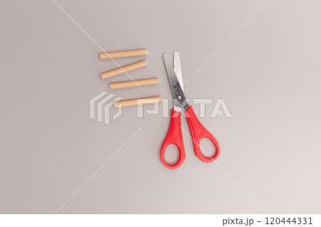 Scissors cutting paper straw in close up step of DIY project, 120444331