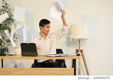 Frustrated office worker throwing documents in anger. Stress at work concept Frustrated office worker throwing documents in anger. Stress at work concept 120444475