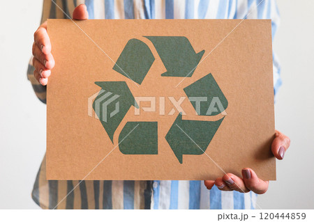 Female hands holding signboard recycling reusing zero waste circular arrow go green closeup Female hands holding signboard recycling reusing zero waste circular arrow go green closeup 120444859