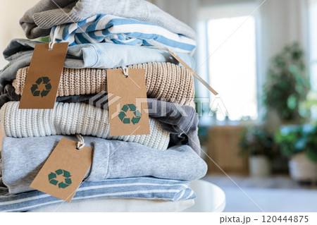 Pile of neatly folded clothes made by recycling material with tag on table top view closeup Pile of neatly folded clothes made by recycling material with tag on table top view closeup 120444875