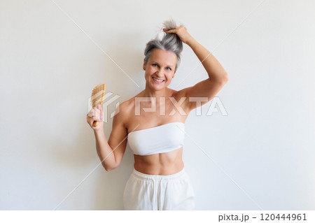 Beautiful gray haired mature woman making hairstyle haircomb posing isolated on white background 120444961