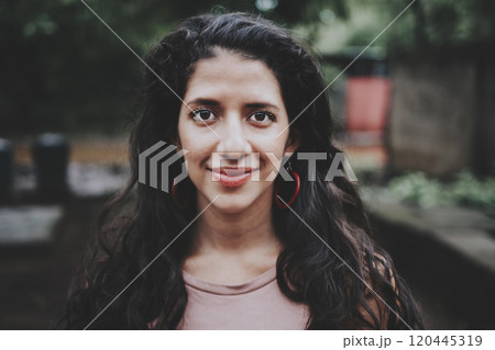 Portrait of attractive latin girl smiling outdoors. Close up of Latin American girl face looking and smiling at the camera. Portrait of young Nicaraguan woman smiling at camera 120445319